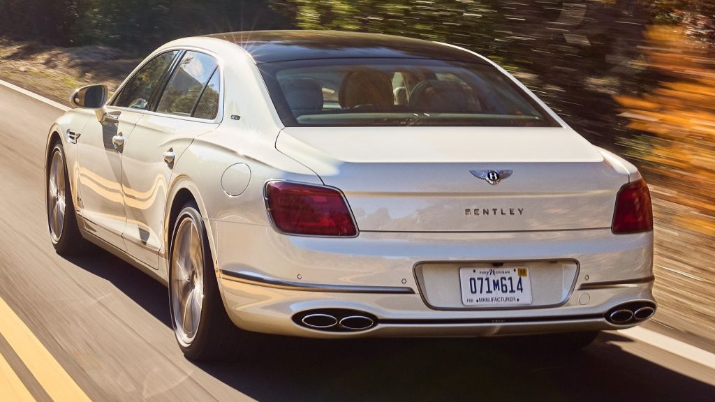 White Bentey Flying Spur 2022 driving down the road rear view