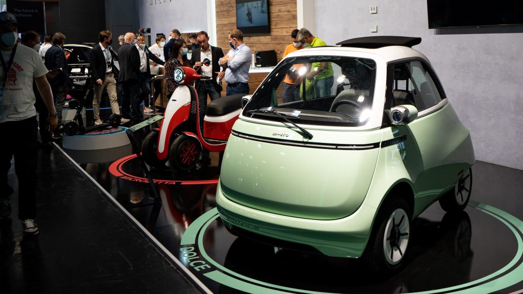 Microlino quadricycle and Microletta scooter at an auto show