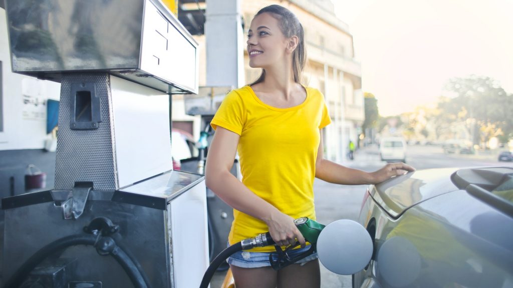Woman at a gas station refueling her car